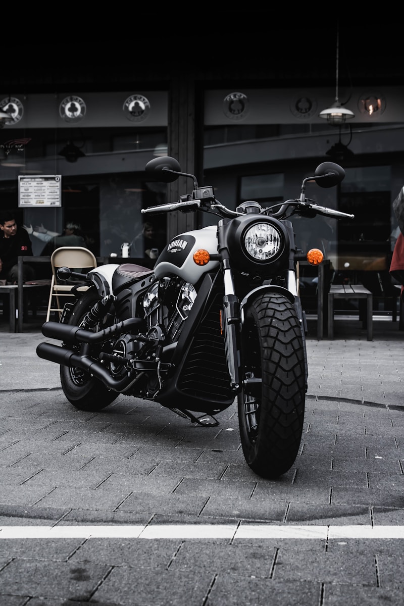 black and gray cruiser motorcycle with motorcycle insurance parked beside black concrete building